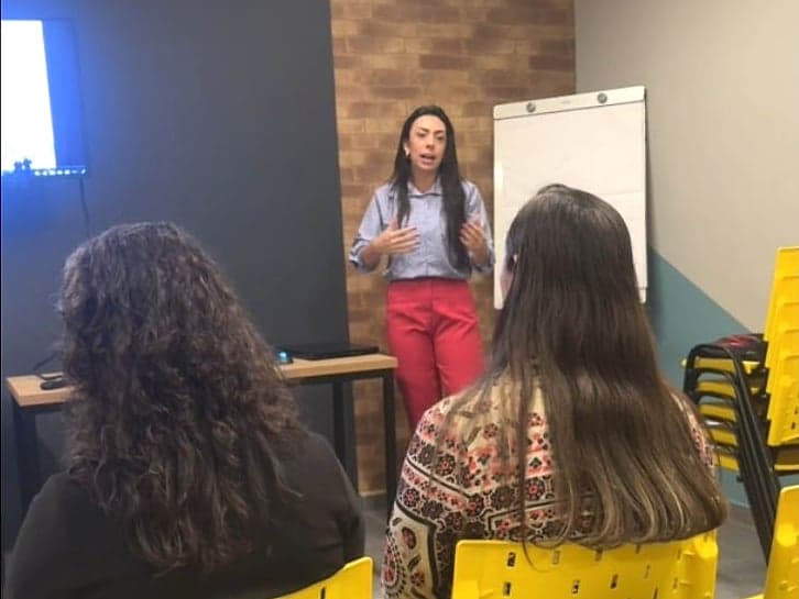 A fundadora da Facilotes treinando uma turma de corretores em sala
